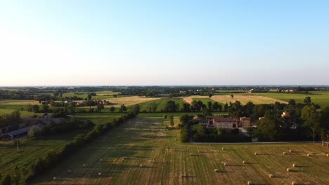 Flying-Over-The-Beautiful-Vast-Field-With-Hay-Bales-On-The-Countryside-In-Reggio-Emilia,-Italy