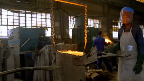 Male-worker-carrying-molten-metal-in-workshop-4k