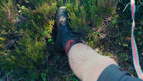 man's leg and foot while sitting on grass