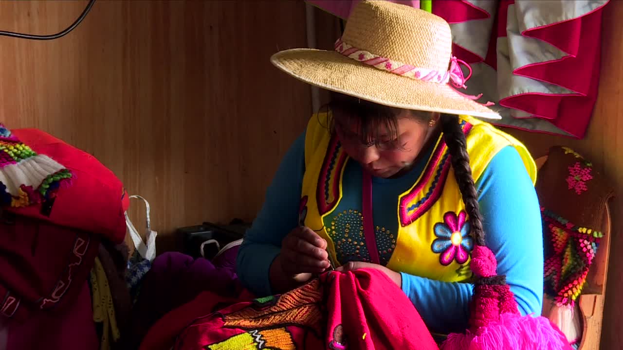 peruvian indigenous weaving traditional clothes inside her bedroom