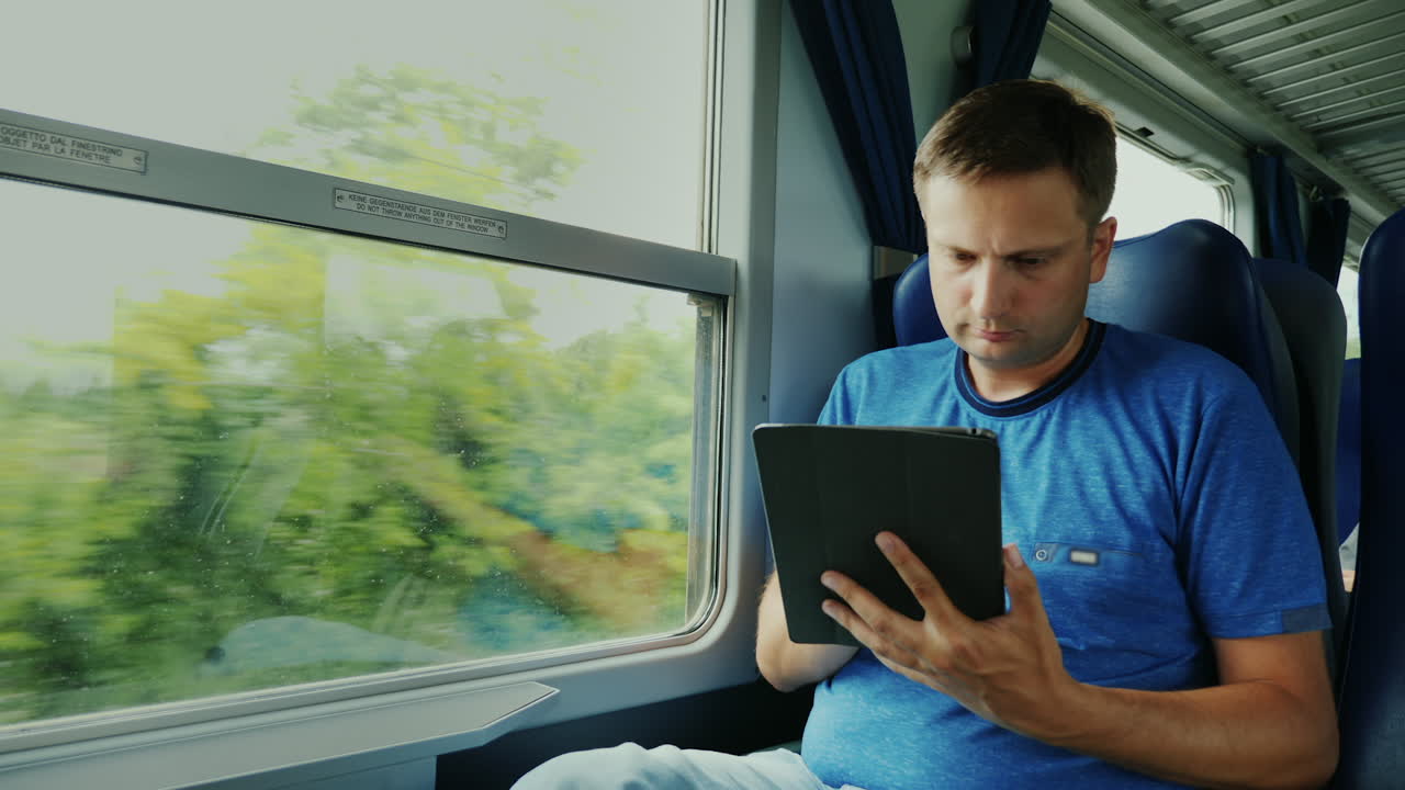 el hombre usa una tableta en un tren