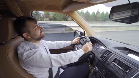 un joven conduciendo por la carretera.