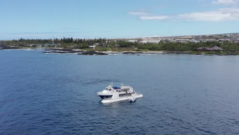 aerial push-in close-up shot of people disembarking a ferry boat and boarding a submarine off the shores of kailua-kona, hawai'i