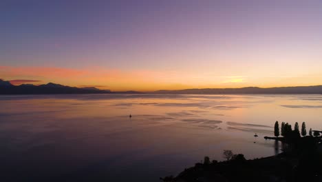 flying high towards sailboat on lake léman with beautiful sunset colors lutry, lavaux - switzerland