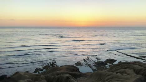 Time-lapse-of-sunset-at-rugged-coastline-in-Croatia-with-gentle-waves-as-the-fiery-sun-dips-below-the-horizon