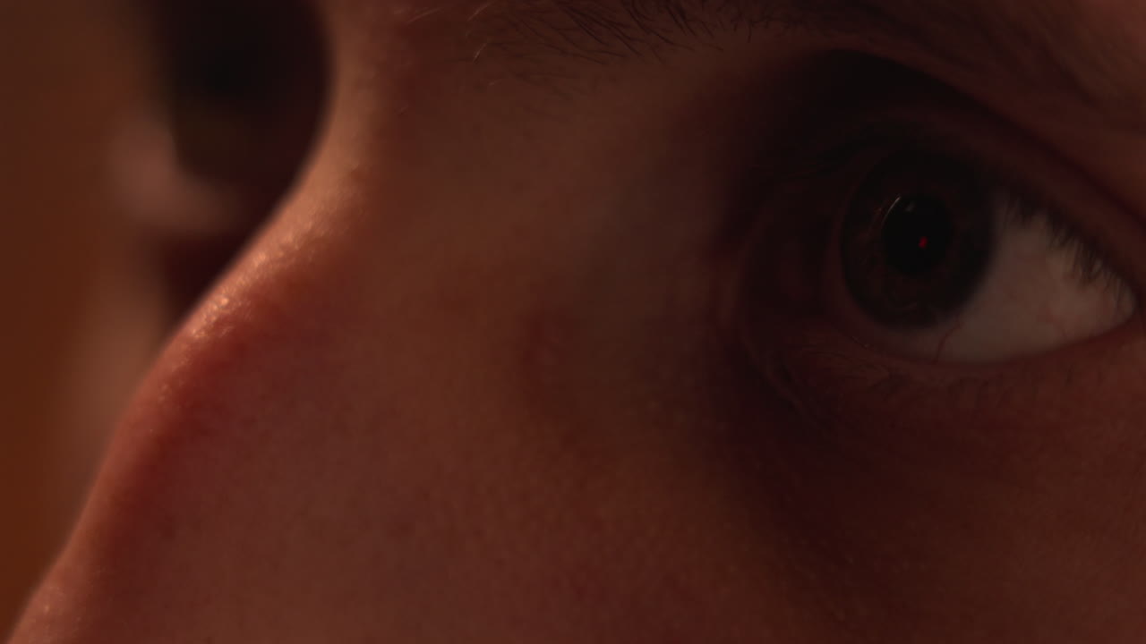 tv 화면에서 넷플릭스 로고를 반영하는 남자의 눈의 클로즈업