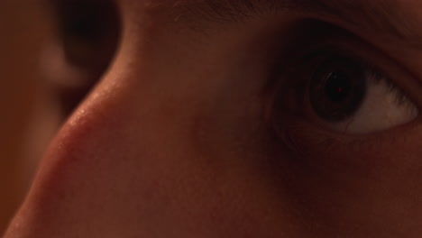 close-up of a man's eye reflecting the netflix logo from a tv screen