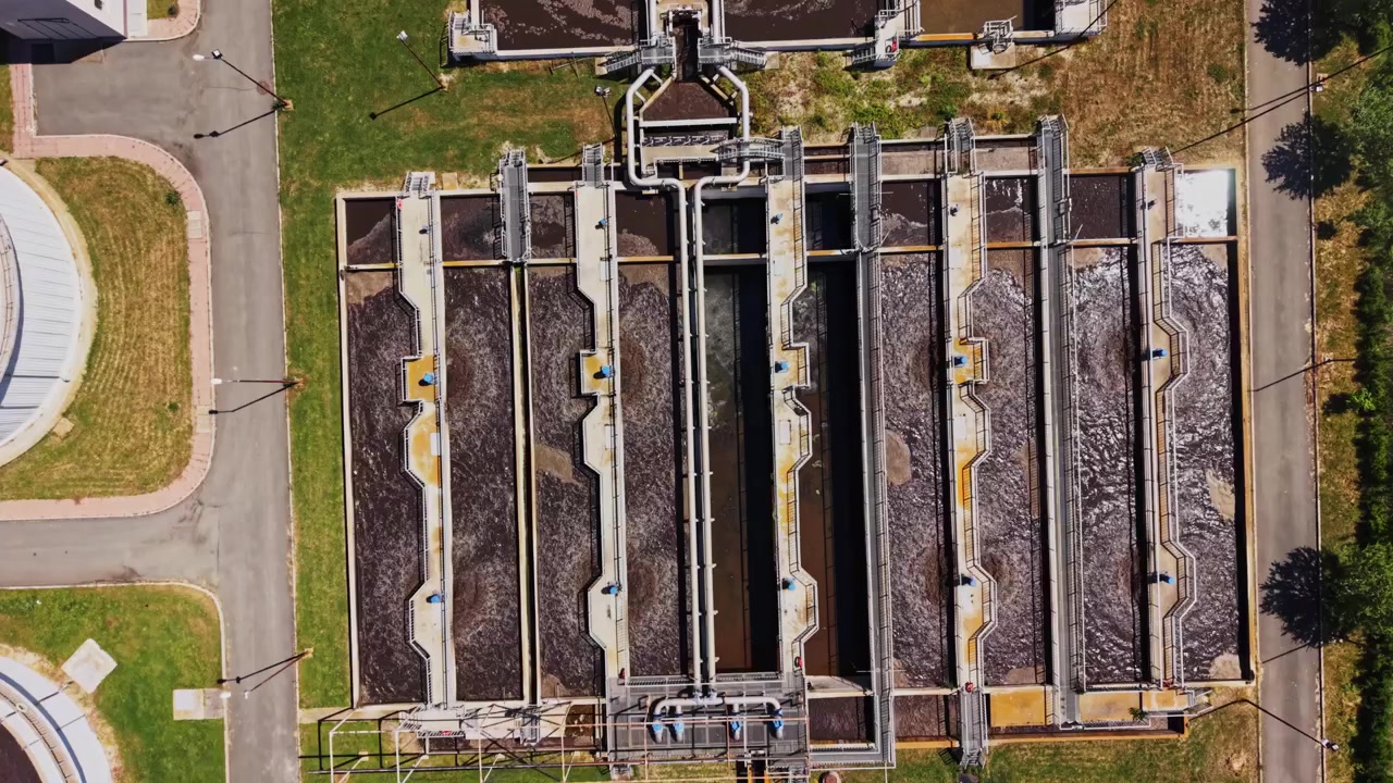 Water treatment facility with circular tanks seen from above in sunlight