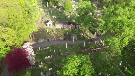 beautiful lush green cemetery with tombstones and mausoleums, aerial view