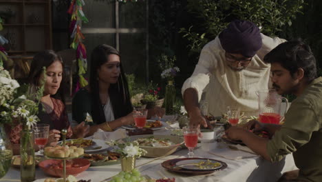 South Asian Family Enjoying an Outdoor Dinner Together
