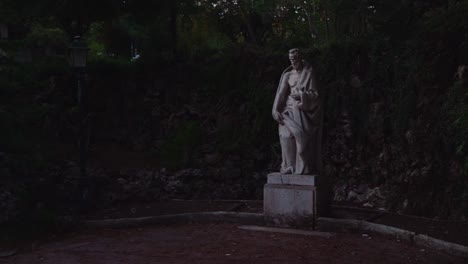 REVEAL-of-a-statue-of-a-man-with-a-street-lamp-by-his-side-in-a-secret-garden