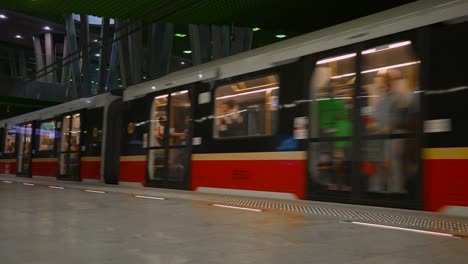 a train full of people arrives at the metro station. stadion narodowy metro station.