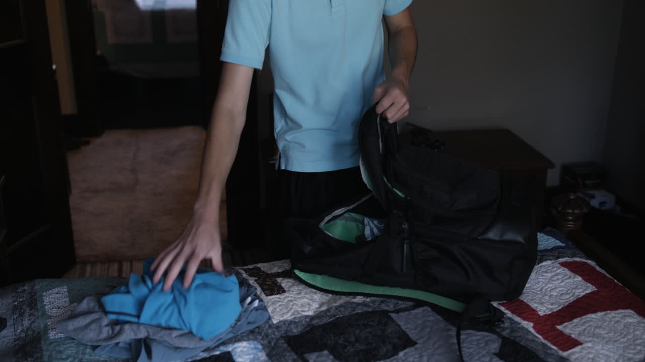 Young man, teenage boy, high school student, packing back pack