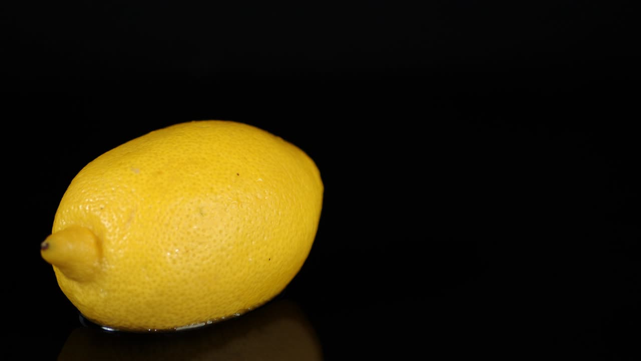 un limón fresco girando en la mesa.