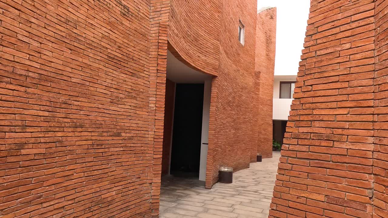 카메라는 구부러진 벽돌 복도를 통해 움직입니다.