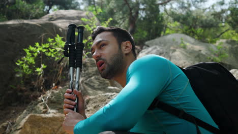 hombre agotado caminando se levanta después de una breve pausa en el bosque de montaña