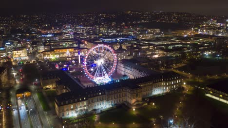 lapso de tiempo de la noche aérea en movimiento en 4k del horizonte del centro de la ciudad de stuttgart, alemania con schlossplatz, la noria länd y el mercado de navidad