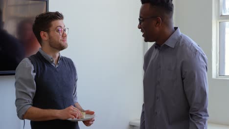 side view of happy young mixed-race business team eating food in a modern office 4k