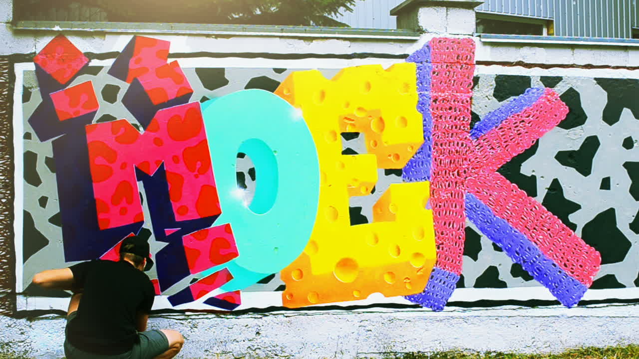 Kunstneren tegner graffiti på et hegn. Abstrakt tegning