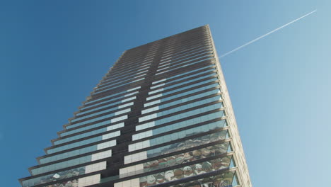 Großer-Turm-An-Einem-Sonnigen-Tag-Ohne-Wolken-Und-Ein-Vorbeifliegendes-Flugzeug