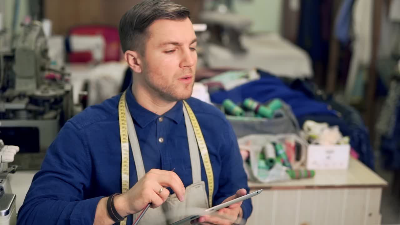 diseñador de ropa masculino ordena material de tableta