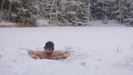 zoom out - an ice bather finishes his daily practice and steps out of his snowy ice hole