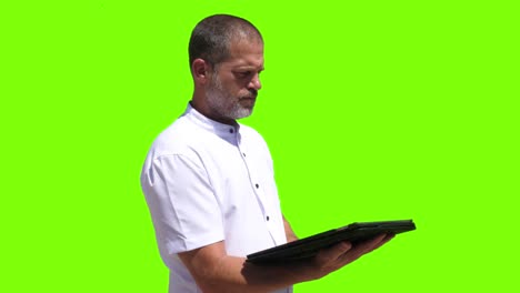 a 40-year-old industrial worker taps on a tablet and then presses a virtual button displayed on a green screen
