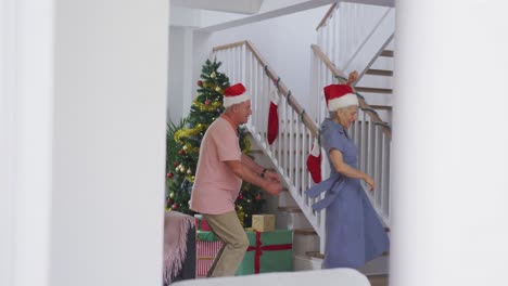 Glückliches-Kaukasisches-älteres-Paar,-Das-Weihnachtsmützen-Trägt-Und-Zur-Weihnachtszeit-Tanzt
