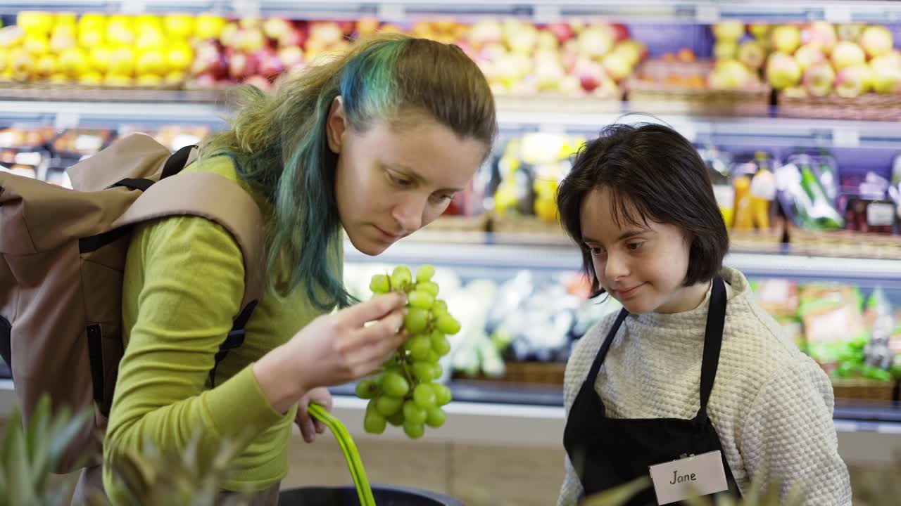 un trabajador de una tienda con síndrome de down ayudando al cliente a elegir frutas frescas
