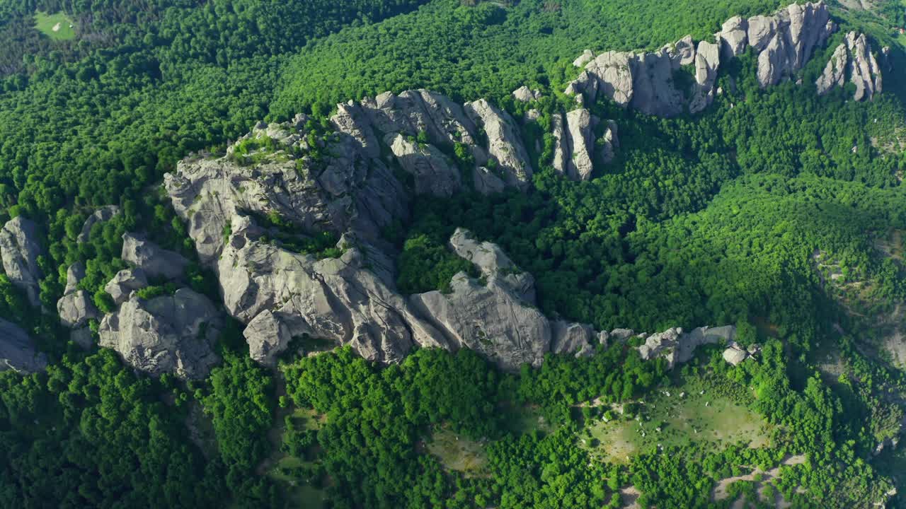 desde el aire abajo de la roca de karadzhov rodeada de verdes montañas rodope en un día de verano - bulgaria, europa