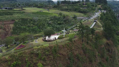 panoramic view of a hilltop cross and green landscape