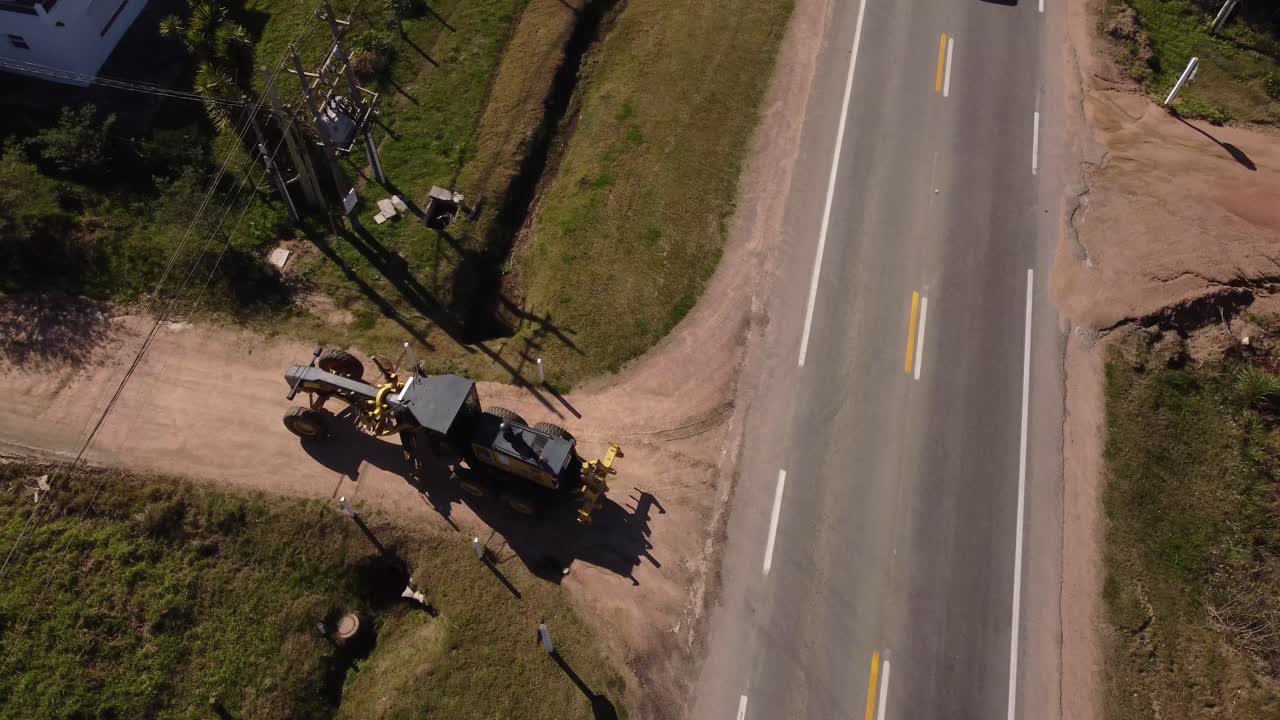 태양에서 건설 현장 도로로 변하는 롤러 차량의 공중 추적 샷