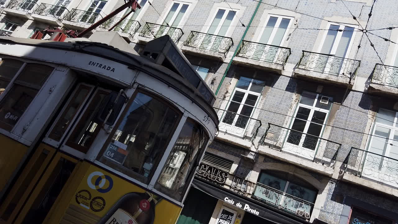 Yellow Tram 28 traveling through historic Alfama, Lisbon, Portugal, angled view