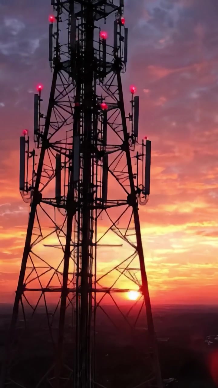 Un Atardecer Dramático sobre Infraestructura Eléctrica: Una Exhibición Artística de Color y Estructura con una Torre Silueteada contra un Cielo Vibrante