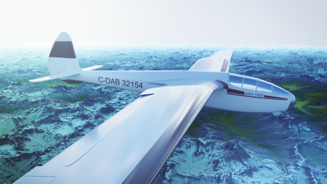 an aerial view of the white sailplane with no propeller calmly gliding in the sky, over snow-covered mountains. flying aerodynamic aircraft is a great way of spend leisure time.