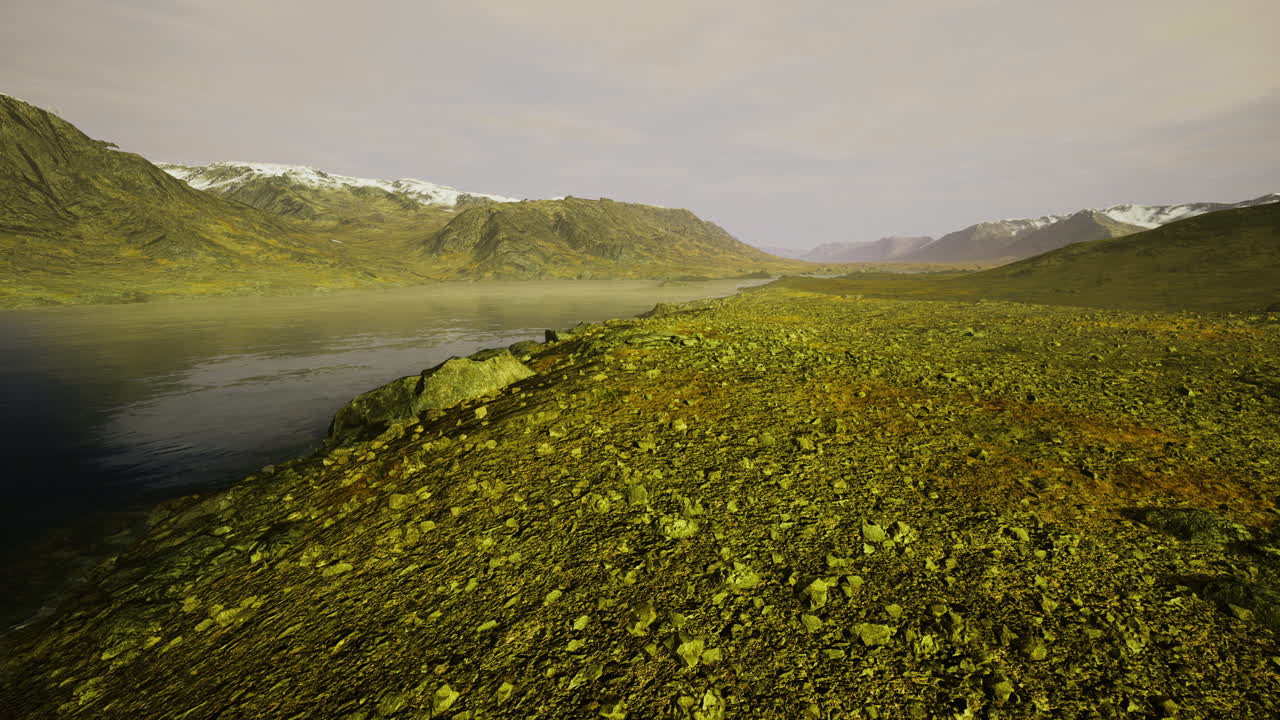 Vast rocky landscape with gentle river flow and distant snow capped mountains