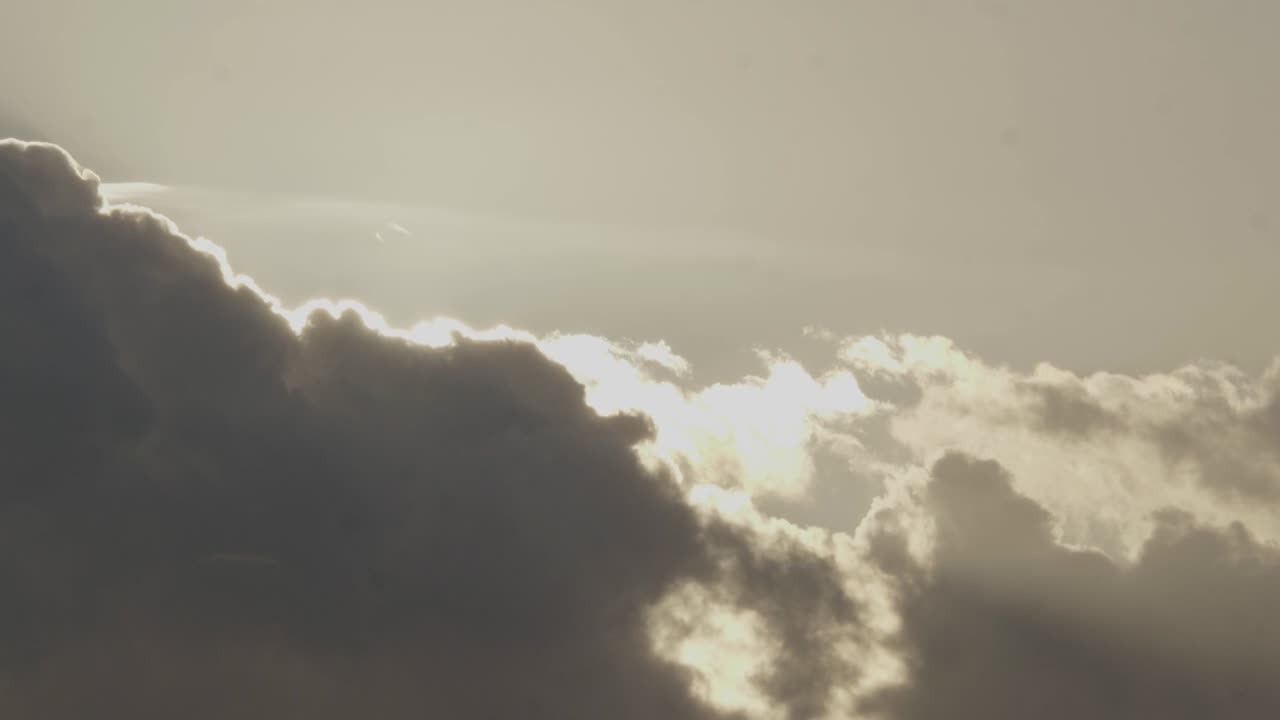 Timelapse of scenic clouds moving through sky with stunning backlight by sun