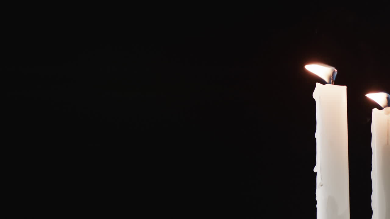 video de dos velas blancas con llama blanca y espacio de copia sobre fondo negro