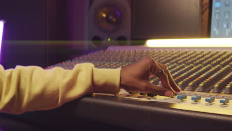 african american man working with mixing console in recording studio