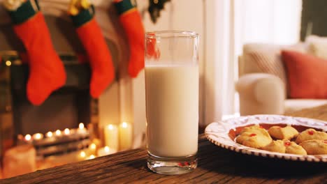 galletas de jengibre con un vaso de leche en una mesa de madera