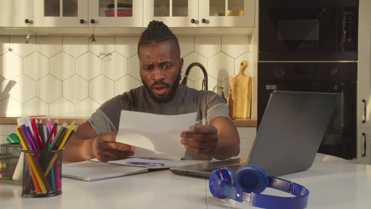 hombre afroamericano guapo conmocionado recibiendo una notificación de desalojo en casa