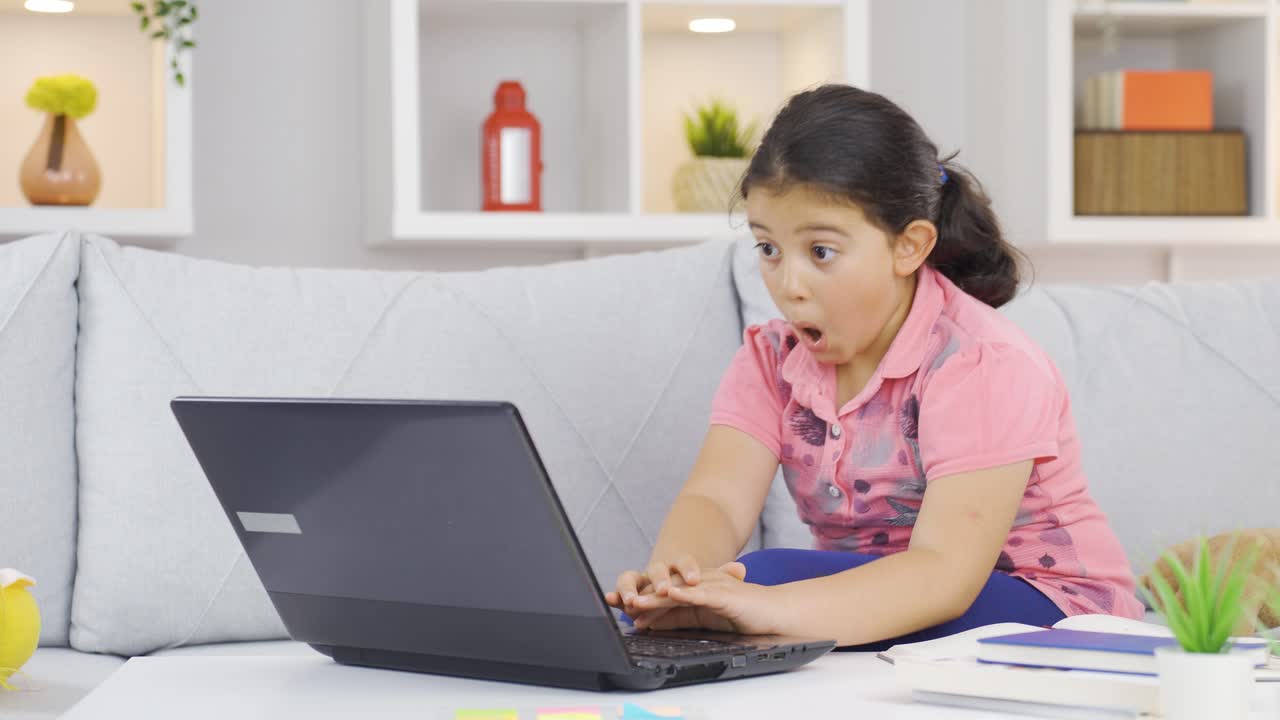 niña inteligente mirando con asombro a los materiales tecnológicos.