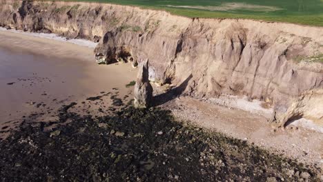 sea stack at ryhope cliffs hendon beach in sunderland north east uk, aerial drone 4k hd fly over