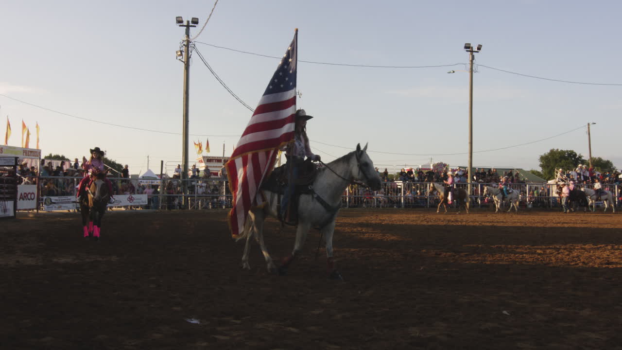 Rider carrying an American flag during a rodeo event