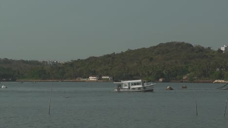 Una-Vista-Desde-La-Orilla-Del-Río-Mandovi-Mientras-Un-Barco-De-Pesca-Comercial-Viaja-Río-Abajo-Para-El-Día-De-Pesca,-Panjim,-India