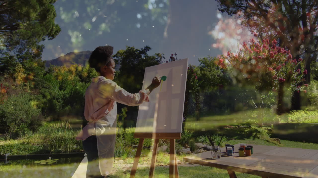 Artist painting on canvas in garden with colorful abstract animation overlay