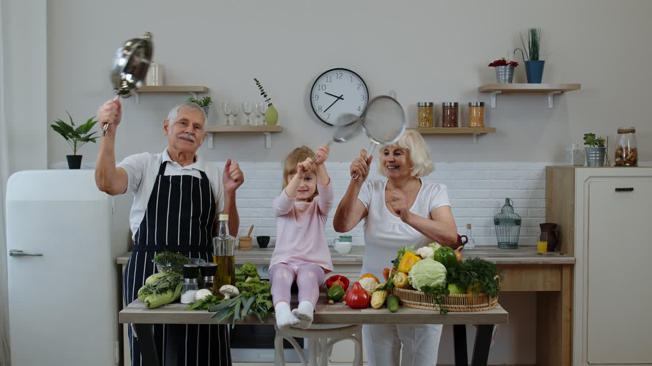старшая женщина и мужчина с внучкой девушка делает смешной танец с фильтром и овощами дома