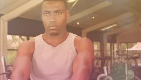 animation of glowing spots over strong man exercising in gym
