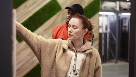 shot assistant helps the woman to choose new wooden laminate