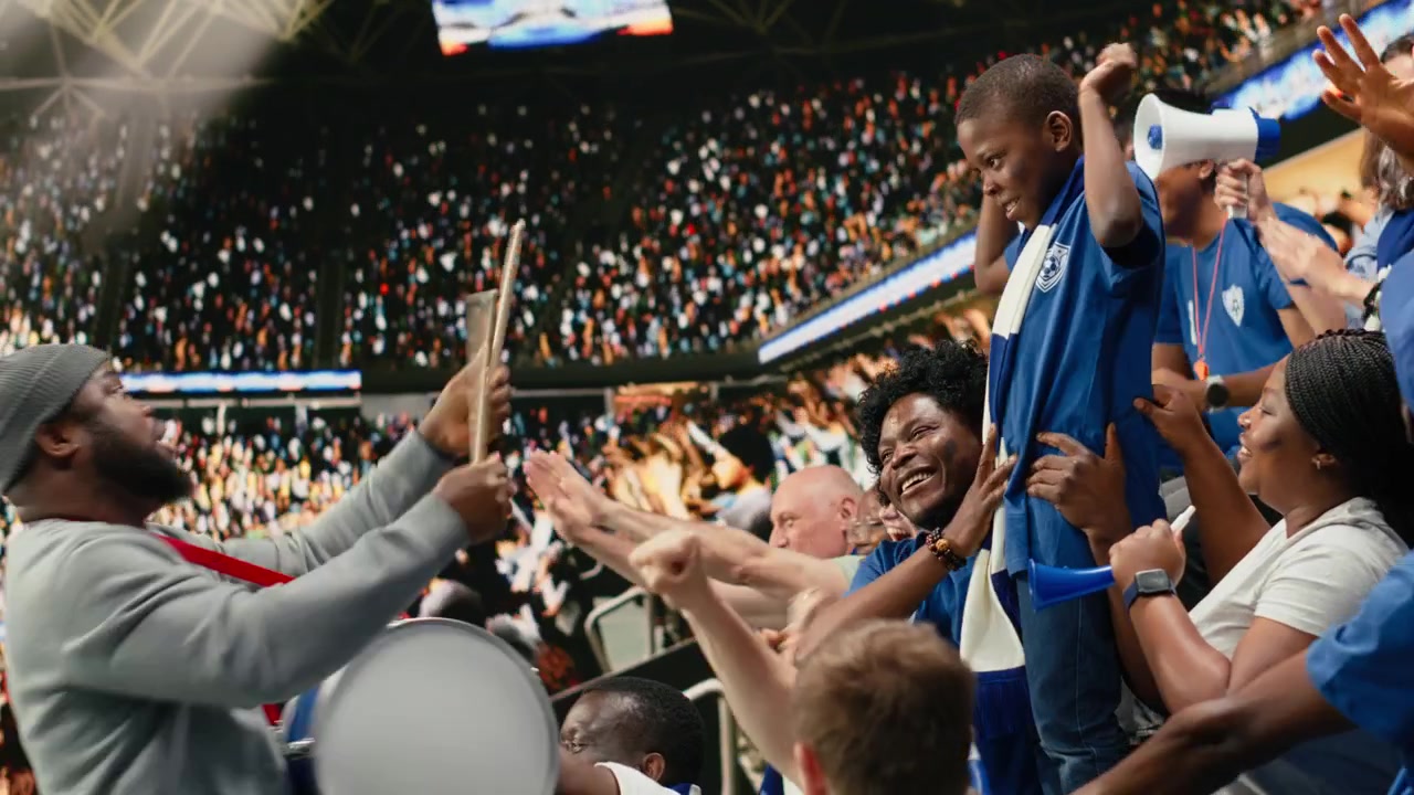 Blue soccer supporters cheering together in crowded stadium during live match